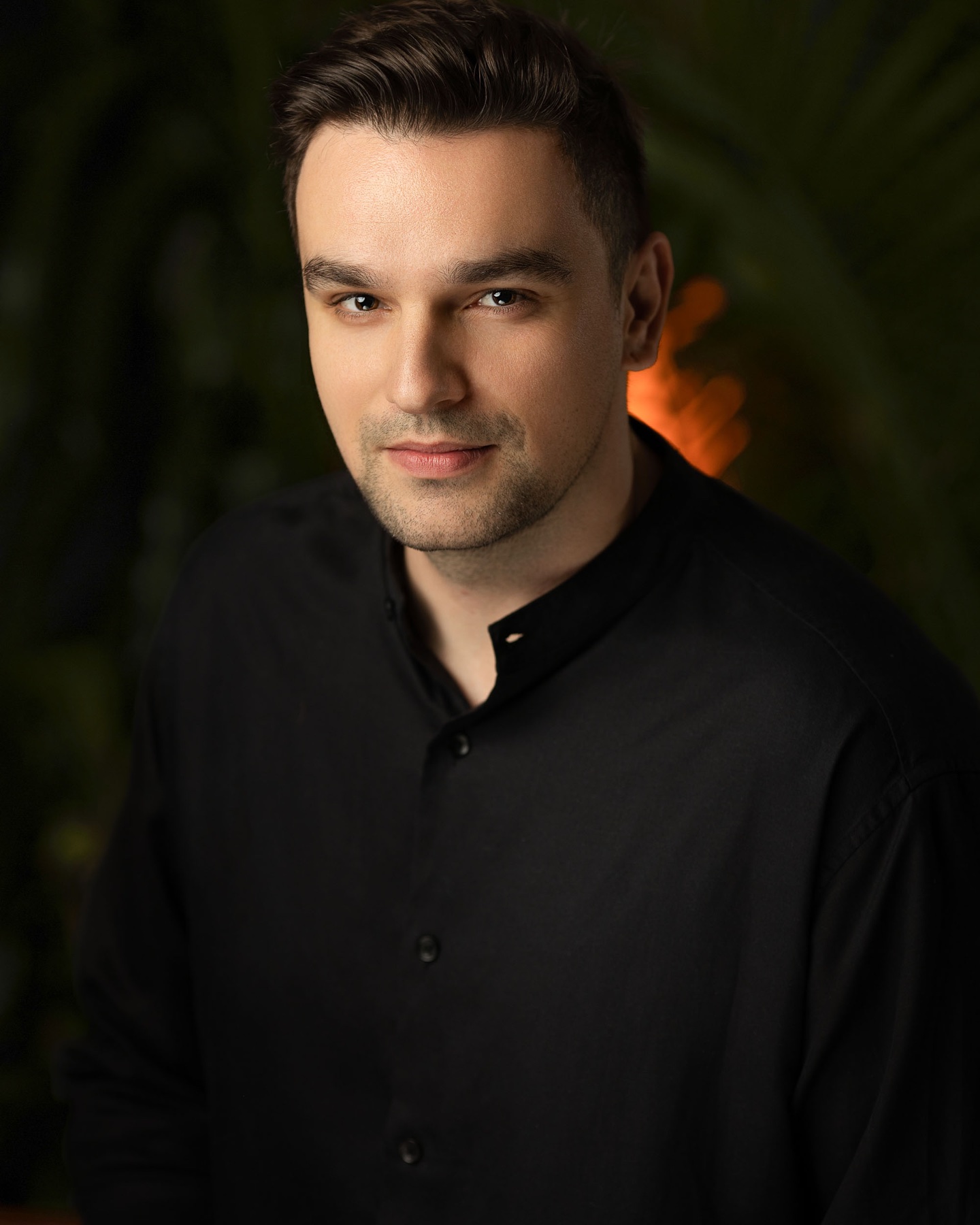 Actor headshot of a man in a black shirt against a dark background
