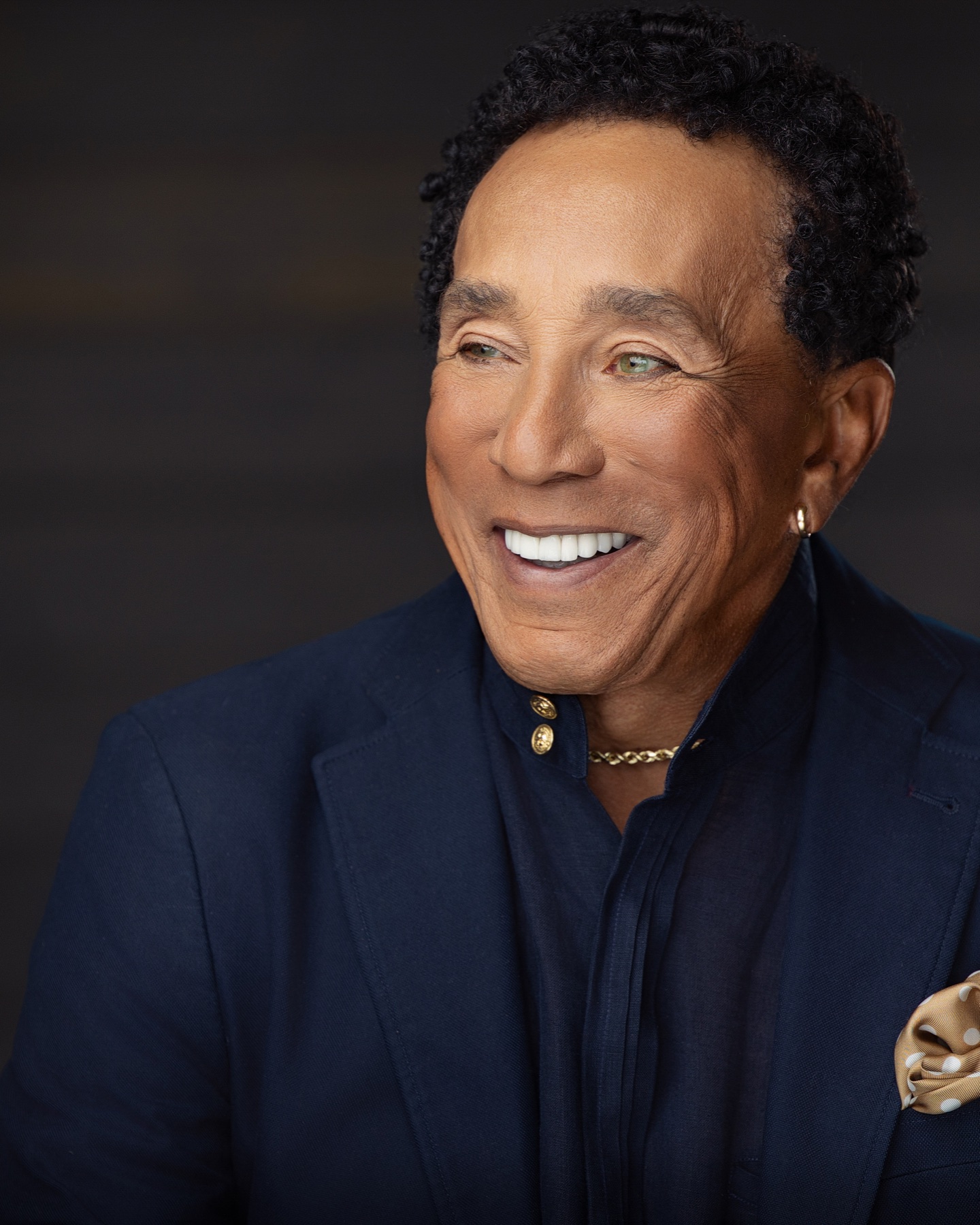 Editorial portrait of a smiling man in a navy suit