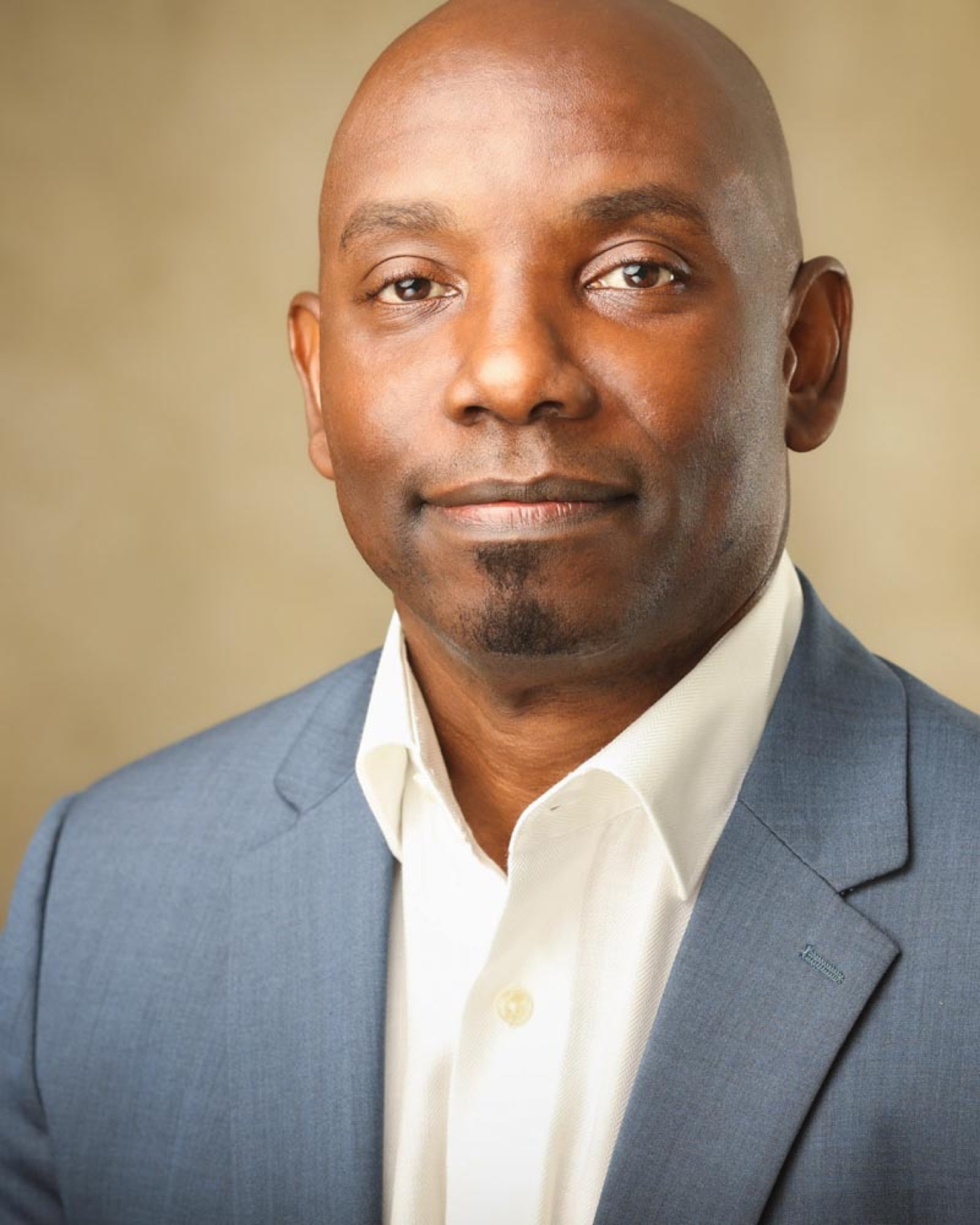 Corporate headshot of a man in a blue suit