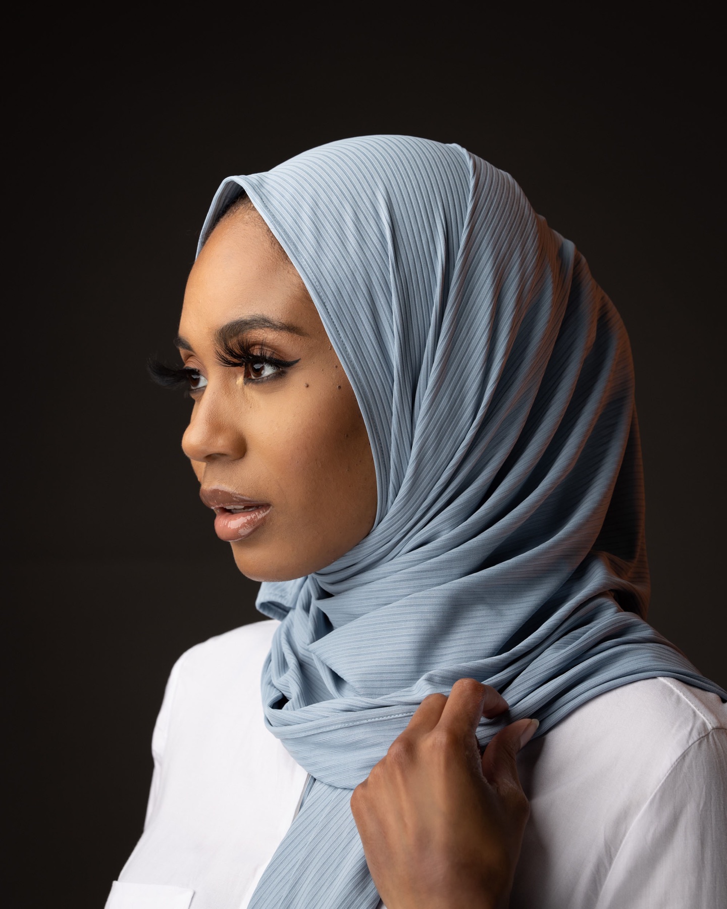 Professional portrait of a woman wearing a pale blue headscarf