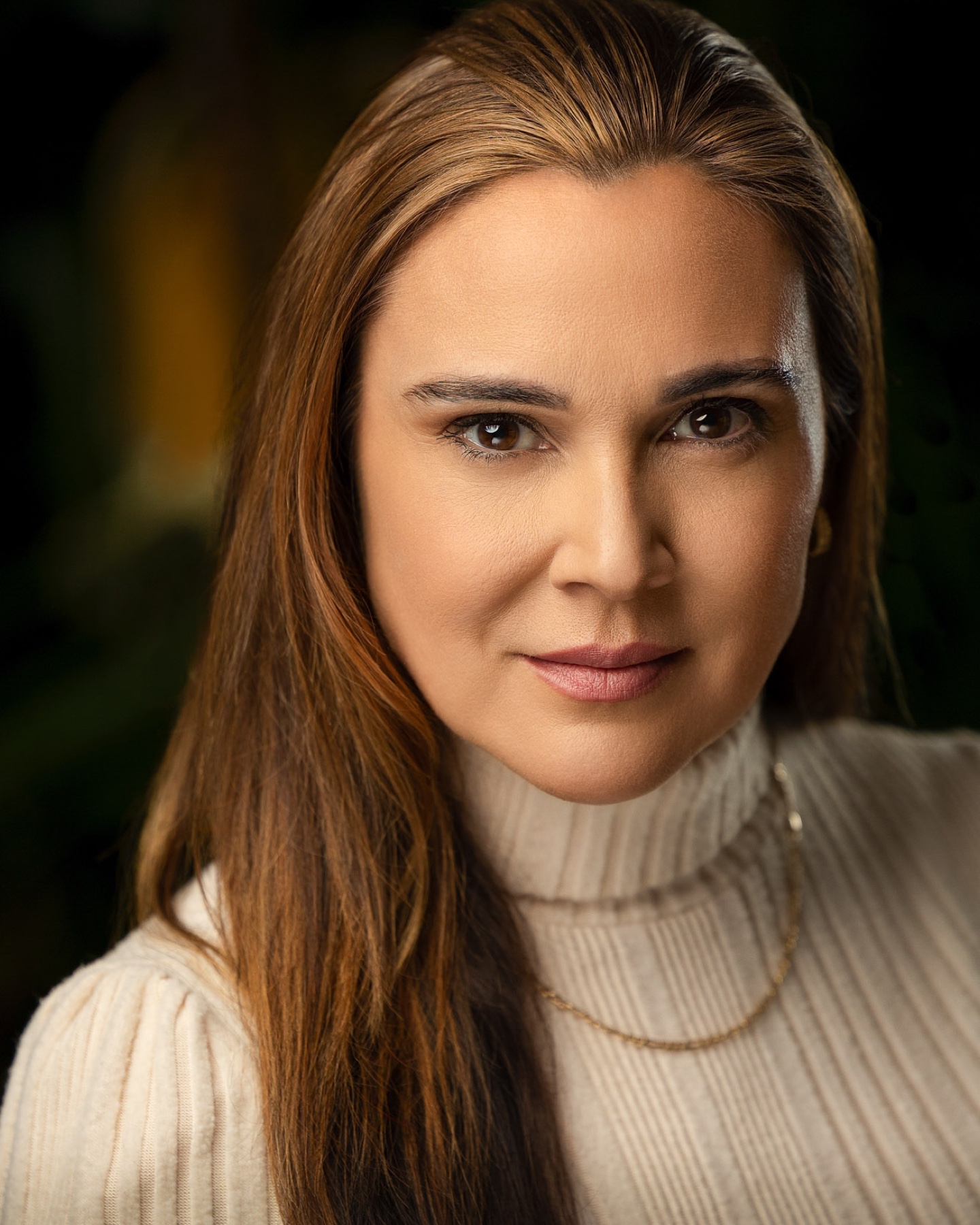 Professional portrait of a woman in a cream turtleneck