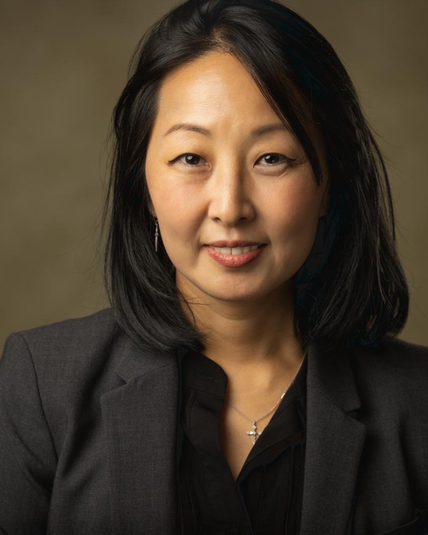 Corporate headshot of a woman in a charcoal blazer