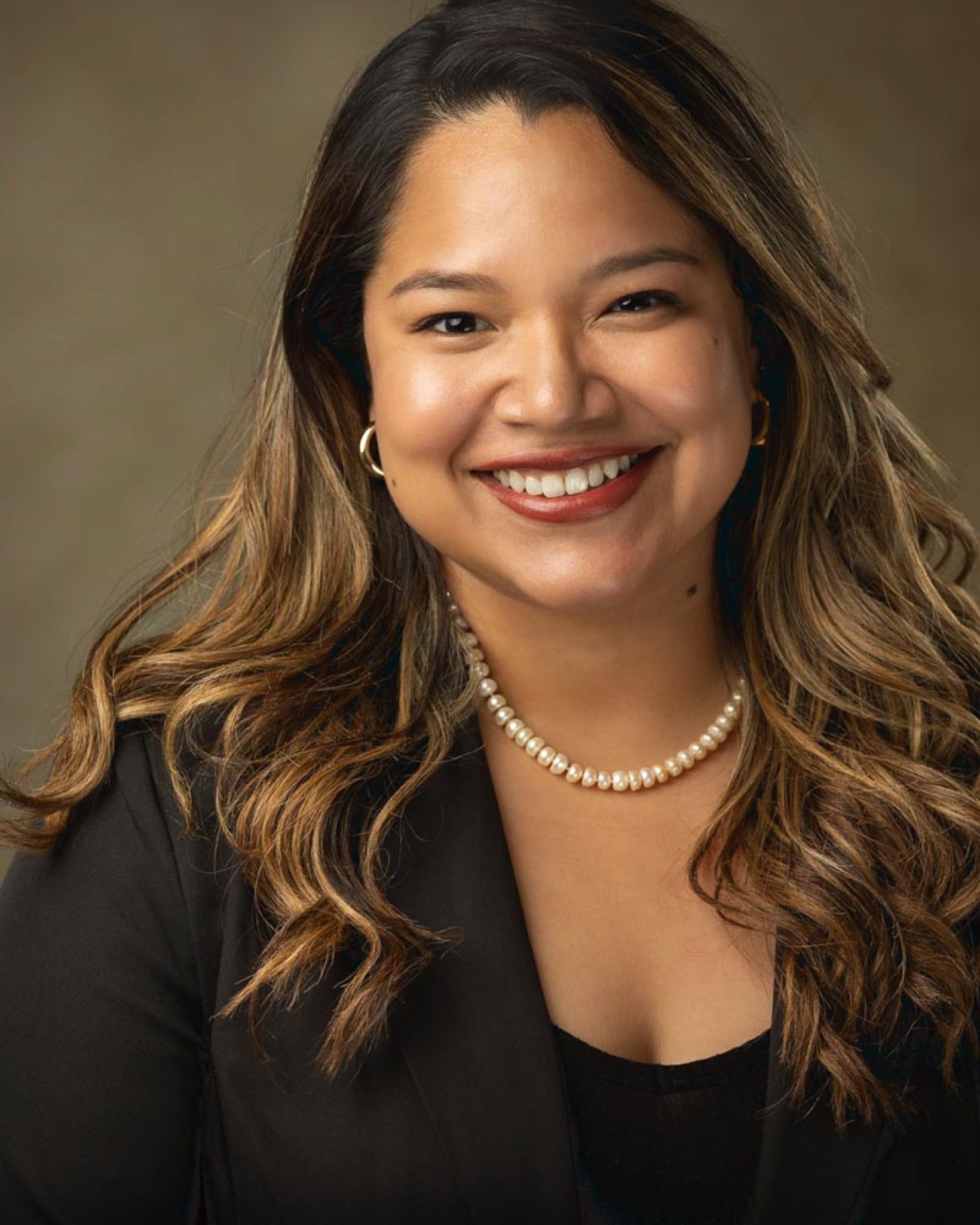 Corporate headshot of a smiling woman wearing pearls