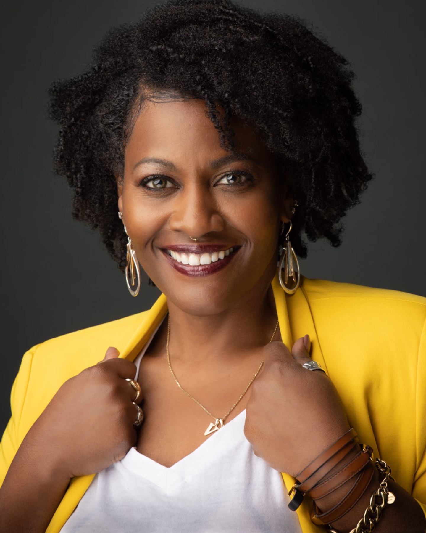 Corporate portrait of a smiling woman in a yellow blazer